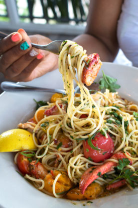 Jocelyn eating lobster spaghetti with a fork served at Perla's