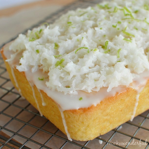 yellow loaf topped with glaze and coconut on wire rack